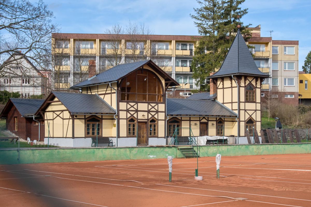 Klubovna TK Bruntál — hrázděná budova s vížkou před antukovými kurty